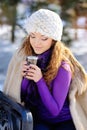 Beautiful girl drinking hot hour outdoors in the winter Royalty Free Stock Photo