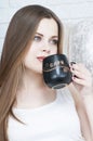 Beautiful Girl Drinking Tea or Coffee. Beauty Woman with Cup of Hot Beverage. Enjoying Coffee. Warm Pastel Colors Royalty Free Stock Photo