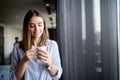 Beautiful girl drinks coffee in the morning. Coffe cup. Window. Fashion