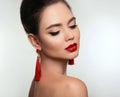 Beautiful girl with earrings jewelry. Beauty face of young brunette woman with a bright make-up and red lips isolated on studio b Royalty Free Stock Photo