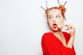 Beautiful girl eating sushi on a white plate. A woman in a red dress and red lips eats chopsticks of sushi with salmon and shrimp Royalty Free Stock Photo