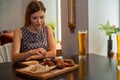 Beautiful girl eats chicken leg with beer in restaurant Royalty Free Stock Photo