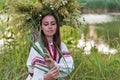 Beautiful girl in embroidery shirt and wreath of wild flowers. Royalty Free Stock Photo