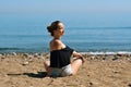 A beautiful girl is engaged in yoga on the beach against the background of the sea. Health and sports. A woman on the ocean shore Royalty Free Stock Photo