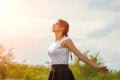 Beautiful girl enjoying the sun with her arms outstretched in the field against the sky Royalty Free Stock Photo