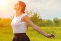 Beautiful girl enjoying the sun with her arms outstretched in the field against the sky Royalty Free Stock Photo