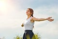 Beautiful girl enjoying the sun with her arms outstretched in the field against the sky Royalty Free Stock Photo