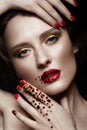 Beautiful girl with evening make-up, red lips in rhinestones and design manicure nails. beauty face. Royalty Free Stock Photo