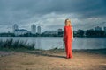 Beautiful girl in evening red dress on the lake with a glass and a bottle of wine Royalty Free Stock Photo