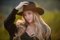 Beautiful girl face closeup, outside portrait of young woman in fashion brim black hat. Summer romantic casual woman Royalty Free Stock Photo