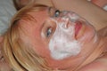 Beautiful girl with face cream. Forty-year-old woman taking care of face