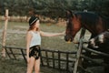 Beautiful girl on the farm feeds the horse. Woman holding farm animals in the forest. Life in the village, a beautiful brunette Royalty Free Stock Photo