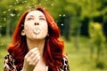 Woman blows away a dandelion