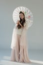 beautiful girl in fashionable winter outfit standing with japanese umbrella Royalty Free Stock Photo