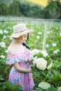 Beautiful girl with a field of hydrangea flowers
