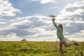 Beautiful girl in a field launches the drone into the sky