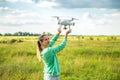 Beautiful girl in a field launches the drone into the sky