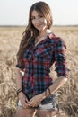 Beautiful girl field. Summer in nature. Happy smiling looking in frame. In the evening shirt a brunette woman, a close Royalty Free Stock Photo