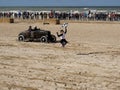 Ouistreham, France September 26, 2020. Beautiful girl with a flag in her hand stands in front of an old motorbike. Racing on a