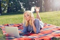 Beautiful girl freelancer listens to music on the grass Royalty Free Stock Photo