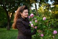 Beautiful girl in garden holds pink roses in hands Royalty Free Stock Photo