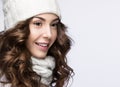 Beautiful girl with gentle makeup, curls and smile in white knit hat. Warm winter image. Beauty face. Royalty Free Stock Photo
