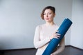 Beautiful girl getting ready for yoga indoors in daylight Royalty Free Stock Photo