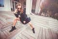 Beautiful girl in glam rock style wear sitting on a steps, drinking street coffee and posing on camera. Feeling of freedom Royalty Free Stock Photo