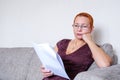 Beautiful girl with glasses looking through tax documents. Emotion of concentration. Serious regulations Royalty Free Stock Photo