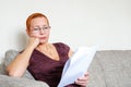 Beautiful girl with glasses looking through tax documents. Emotion of concentration. Serious regulations Royalty Free Stock Photo