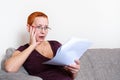 Beautiful girl with glasses looking through tax documents. Emotion of concentration. Serious regulations Royalty Free Stock Photo