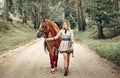 Beautiful girl goes on the road with a horse