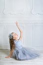 Beautiful girl in gray dress and pointe shoes is posing on the f Royalty Free Stock Photo