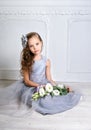 Beautiful girl in gray dress and pointe shoes is posing on the floor in the room Royalty Free Stock Photo