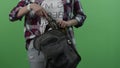 Beautiful girl on green background. Woman cleans a vintage gun in a backpack on green skreen