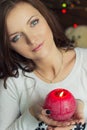 beautiful girl with green eyes with a red candle in his hand