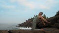 Girl raises hands getting into ushtrasana at sea slow motion