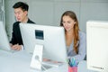 Beautiful girl with grey suit sit near to young man and they work as operator in the company Royalty Free Stock Photo