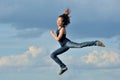 Beautiful girl in gymnastic jump against blue sky Royalty Free Stock Photo