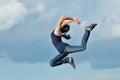 Beautiful girl in gymnastic jump against blue sky Royalty Free Stock Photo