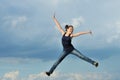 Beautiful girl in gymnastic jump against blue sky Royalty Free Stock Photo