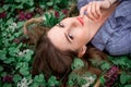 A girl with hand is lying on the grass in flowers Royalty Free Stock Photo