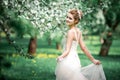 Beautiful girl hands with a branch of a blossoming apple tree. Young beautiful blonde woman in blooming garden. Royalty Free Stock Photo