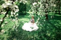 Beautiful girl hands with a branch of a blossoming apple tree. Young beautiful blonde woman in blooming garden. Royalty Free Stock Photo