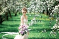 Beautiful girl hands with a branch of a blossoming apple tree. Young beautiful blonde woman in blooming garden. Royalty Free Stock Photo