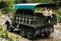 A beautiful girl and a handsome man in military truck. Lovestory. Military vehicle. Military fashion.Carpathian mountains