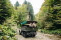 A beautiful girl and a handsome man in military truck. Lovestory. Military vehicle. Military fashion.Carpathian mountains