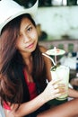 Beautiful girl with the hat, drinking fresh and refreshing pineapple juice, summer holiday vacation