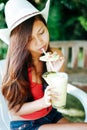 Beautiful girl with the hat, drinking fresh and refreshing pineapple juice, summer holiday vacation