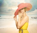 Beautiful girl in a hat enjoying the sun on the beach. Royalty Free Stock Photo